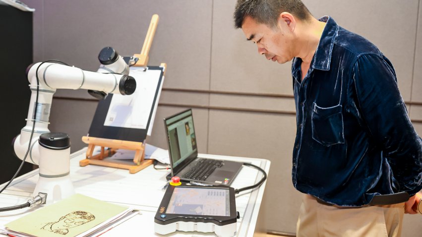 嘉賓體驗遨博AI繪畫機器人。主辦方供圖